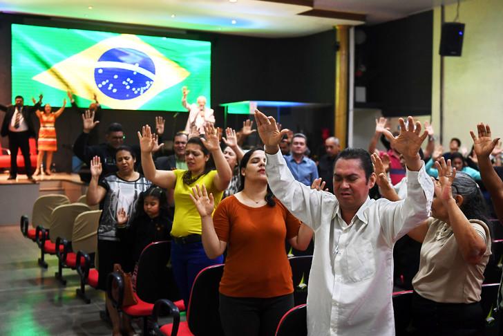 Evanjelikler, 21 Eylül 2018'de Brezilya da yapılan birinci tur cumhurbaşkanlığı seçimlerinin aşırı sağcı adayı olan Jair Bolsonaro'nun eski haline getirilmesi için kilisede dua ediyor - La Croix.jpg