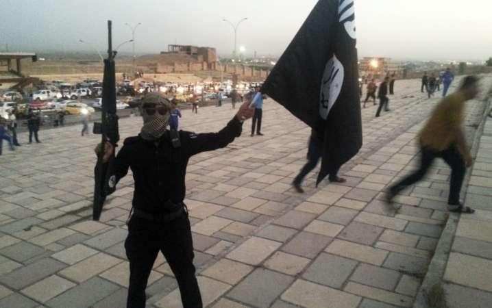 Musul'e işgal eden IŞİD'in bir militani elindeki bayrakla gösteri yapıyor. Haziran 2014-Reuters.jpg