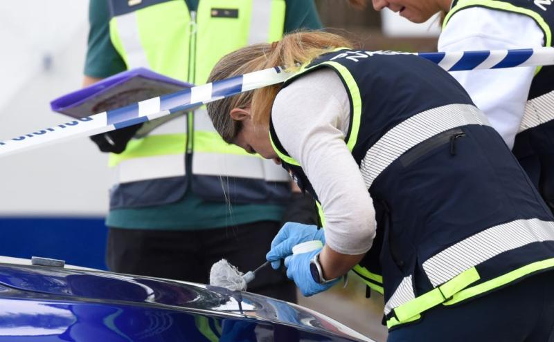 Bir kadın polis, suç mahallinde parmak izi alıyor.jpg