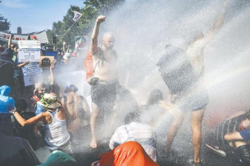 Hollanda polisi, iklim aktivistlerine tazyikli su sıkıyor. Fotoğraf-AFP.jpg