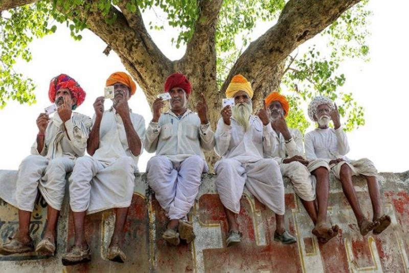 Seçmenler Rajasthan'ın Ajmer kentindeki bir oy verme merkezinin yakınında mürekkepli parmaklarını gösteriyor.jpg