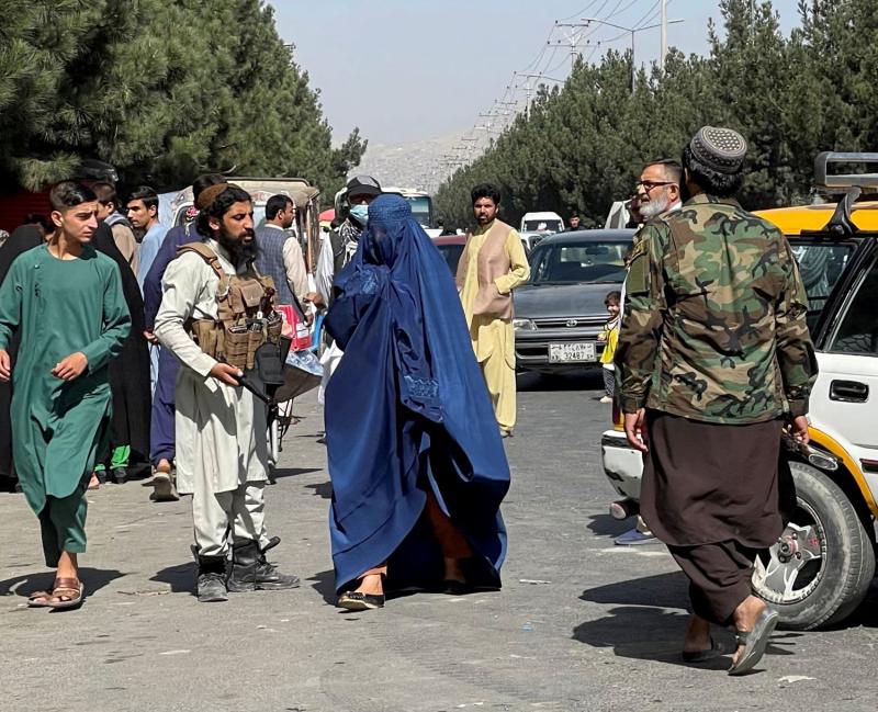 Taliban üyelerinin etrafını sardığı bir Afgan kadını (Arşiv - Reuters.jpg