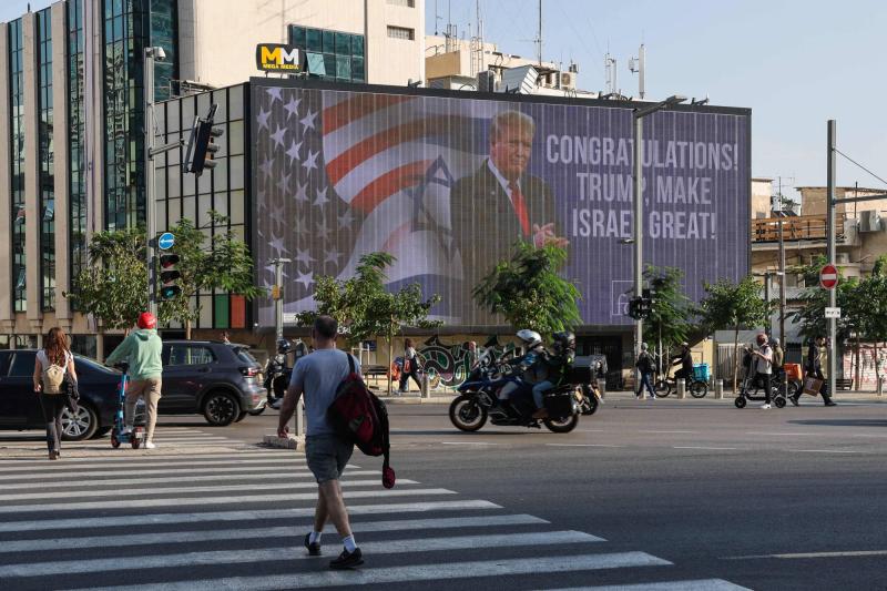 Tel Aviv'deki bir kavşakta Donald Trump'ı tebrik eden büyük bir reklam panosunun önünden geçen arabalar, 6 Kasım 2024 / Fotoğraf: AFP