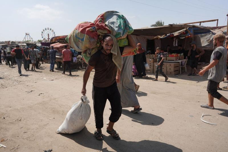 Gazze Şeridi'nin güneyindeki Han Yunus IDP kampında eşyalarını taşıyan bir Filistinli, 18 Ağustos 2024 / Fotoğraf: AFP