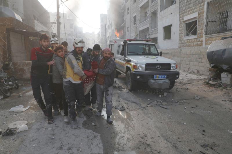 Beyaz Baretliler olarak bilinen Suriye Sivil Savunması üyeleri ve siviller, Suriye rejimi güçlerinin İdlib'e yönelik bombardımanında yaralanan bir kişiyi taşırken, 2 Aralık 2024 / Fotoğraf: AP