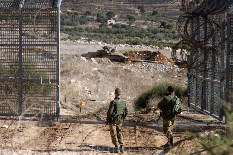 Bir tankın Golan Tepeleri'ndeki tampon bölgenin çitlerini geçmesini izleyen İsrail askerleri / Fotoğraf: AFP