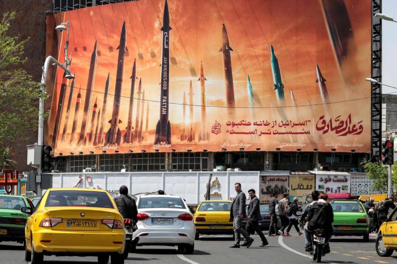 Tahran'ın merkezindeki Vali Asr Caddesi’nde, alt kısmında Arapça olarak "Dürüst Söz" ve Farsça olarak "İsrail örümcek ağından daha zayıftır" yazılı İran yapımı balistik füzelerin yer aldığı bir billboard, 15 Nisan 2024 / Fotoğraf: AFP